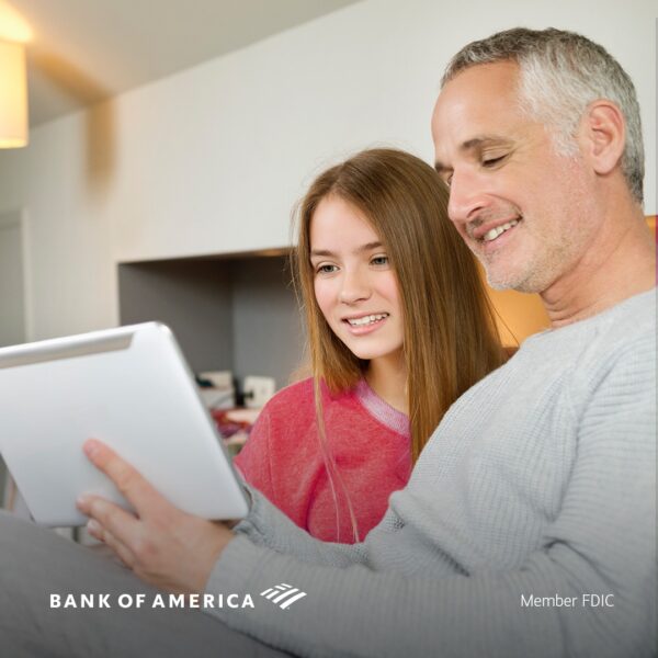Father showing daughter banking on computer